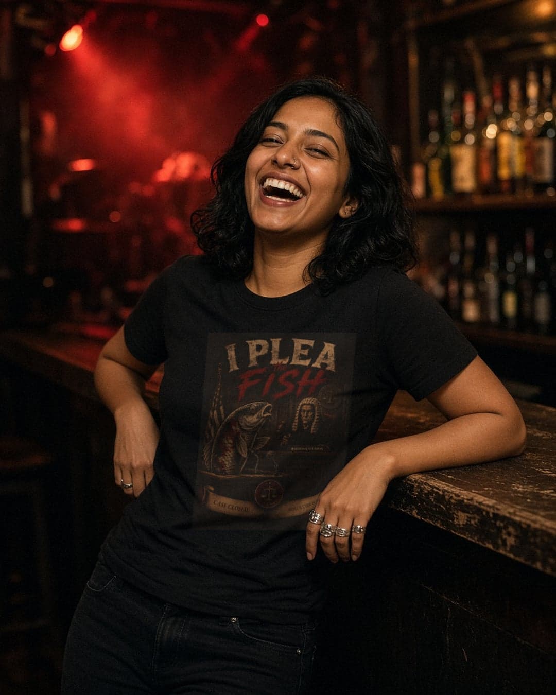 AI-generated image: a person laughing at a bar under red stage lights, wearing the RAIDFISH STUDIOS I Plea the Fish tee